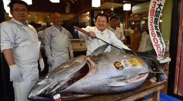 Pengusaha restoran sushi Jepang, Kiyoshi Kimura memamerkan ikan tuna sirip biru seberat 278 kg di restorannya, Tokyo, Sabtu (5/1). Tuna raksasa itu dibeli dalam lelang perdana 2019 dengan harga USD3,1 juta atau setara 43,4 miliar. (Kazuhiro NOGI/AFP)