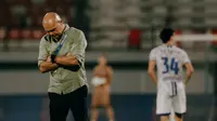 Pelatih Bali United, Johnny Jansen, tertunduk lesu setelah timnya hanya bermain imbang tanpa gol saat menjamu Persijap Jepara pada lanjutan BRI Super League 2025/2026, Sabtu (28/2/2026) malam WIB. (Bola.com/Alit Binawan)