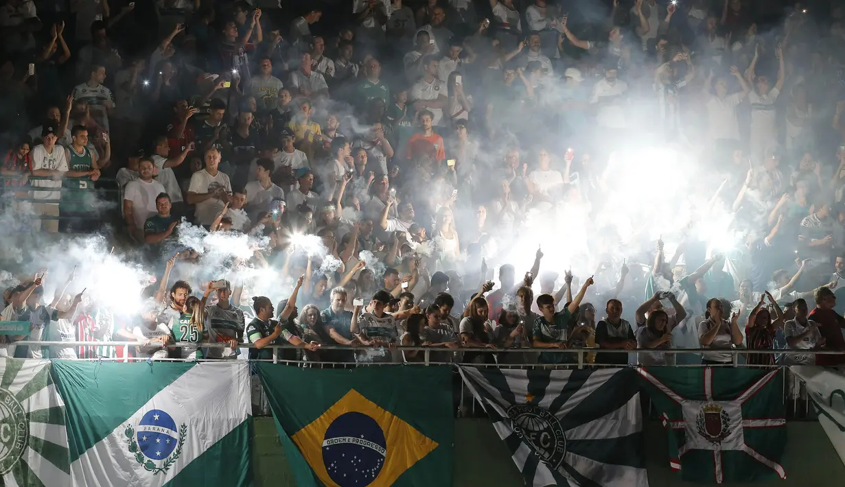 Suporter Chapecoense memberikan penghormatan kepada para pemain klub kesayangannya yang meninggal akibat kecelakaan pesawat. Pada laga Copa Sudamericana tersebut harusnya mereka bertanding melawan Atletico Nacional. (EPA/Hedeson Alves)