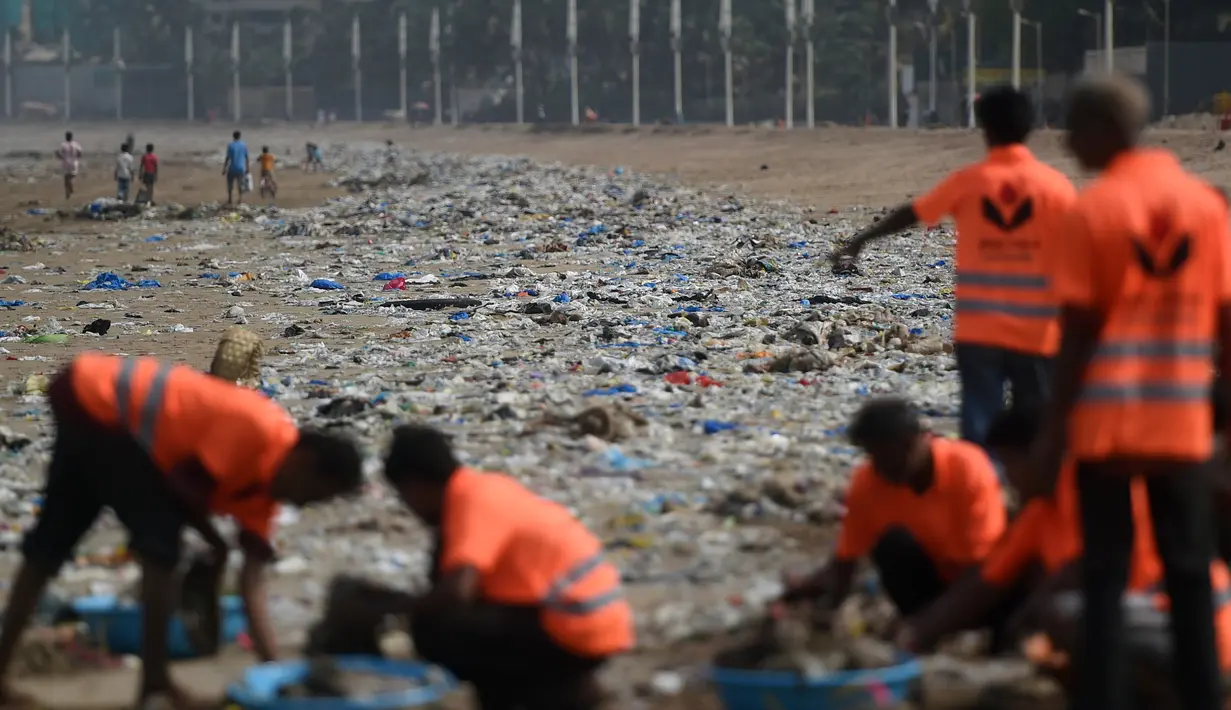 Petugas membersihkan sampah plastik di pantai Juhu di Mumbai, India (2/6). (AFP PHoto/Punit Paranjpe)