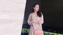 Mengenakan dress panjang model lace warna pink, Kusuma Puteri juga membawa tas warna senada dari Chanel dengan tali rantai yang khas. [@kusumaputeri]