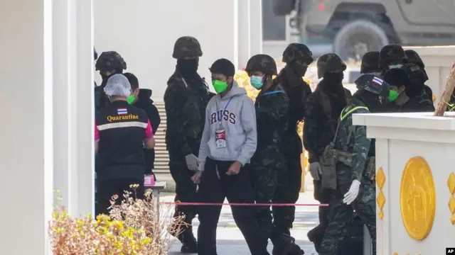 WNI korban kasus 'online scam' di Myanmar timur dikawal tentara Thailand setibanya di Mae Sot, Provinsi Tak Kamis, 27 Februari 2025. Mereka akan dipulangkan ke Indonesia. (Sakchai Lalit/AP)