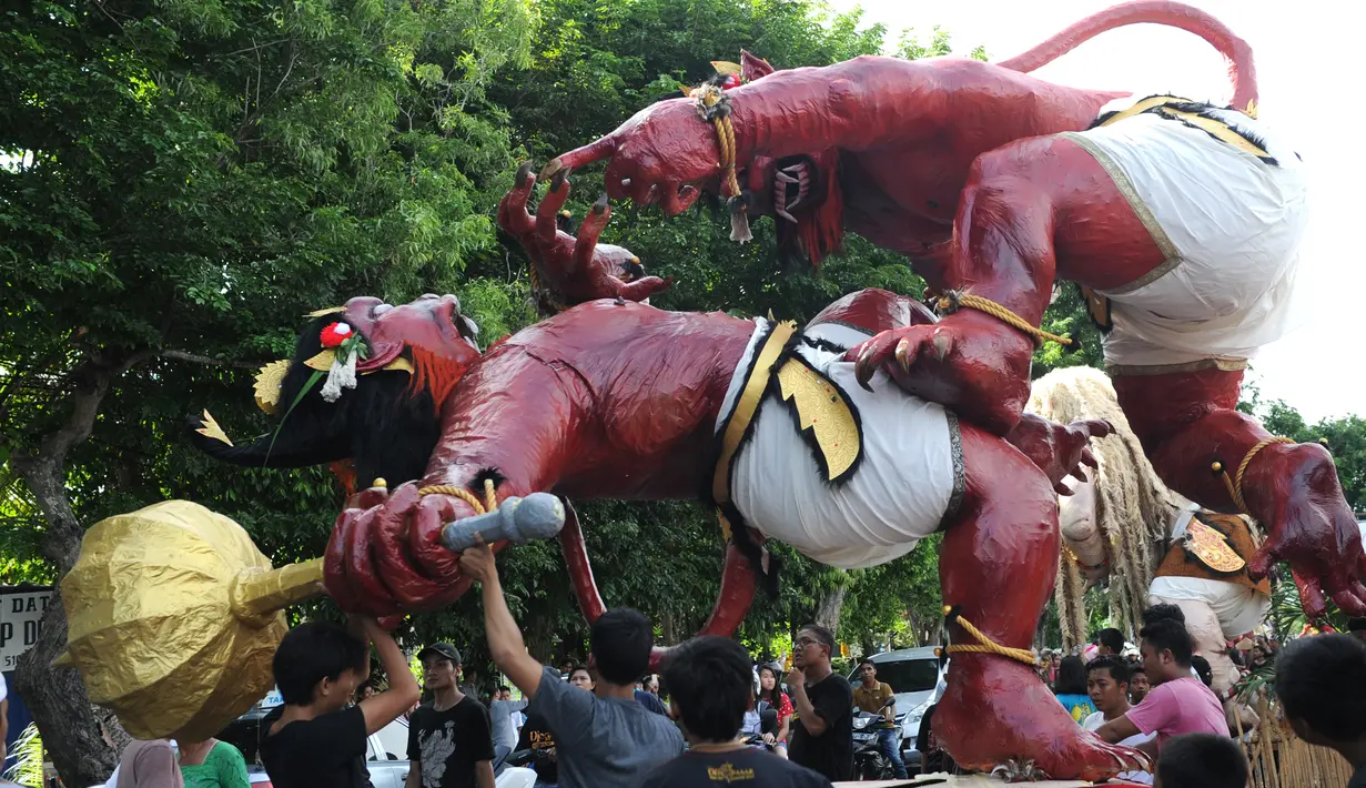 Umat Hindu Bali menyiapkan Ogoh-Ogoh sebelum parade hari Nyepi di Denpasar, Bali, Senin (27/3). Umat Hindu di Bali akan merayakan hari raya Nyepi Tahun Baru Saka 1939 pada tanggal 28 Maret 2017. (AFP Photo / Sonny Tumbelaka) 