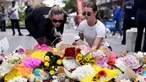 Orang-orang meletakkan bunga di luar pusat perbelanjaan Westfield Bondi Junction di Sydney pada 14 April 2024. (DAVID GRAY/AFP)