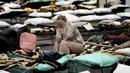 Seorang wanita meletakkan kepala pada tangannya saat duduk dalam penampungan orang terlantar yang melarikan diri dari Ukraina di sekolah di Przemysl, Polandia, 8 Maret 2022. PBB mengatakan, serangan gencar Rusia telah memaksa lebih dari 2 juta orang meninggalkan Ukraina. (AP Photo/Markus Schreiber)