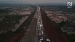 Foto udara kepadatan pemudik untuk keluar dari ruas Tol Batang-Semarang menuju jalur Pantura Batang-Kendal di Kali Kuto, Gringsing, Kabupaten Batang, Jawa Tengah, Senin (11/6). (Liputan6.com/Arya Manggala)