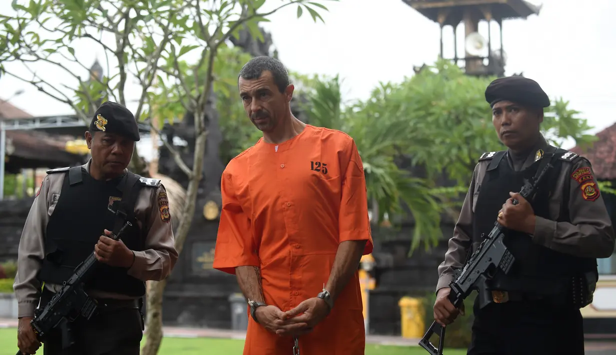 Warga negara Prancis Samuel Pierre Danguny dikawal dua polisi sebelum konferensi pers di kantor polisi di Denpasar, Bali (18/3). Danguny ditangkap pada 15 Maret dengan kepemilikan 33 gram ganja dan 2 paket Hasis 16 gram. (AFP Photo/Sonny Tumbelaka)