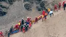 Petugas penyelamat mengelilingi tubuh salah satu korban terluka setelah sebuah bus jatuh dari tebing di Pasamayo, Peru, Selasa (3/1). Sebelum terjun ke jurang, bus sempat bertabrakan dengan sebuah truk trailer. (Vidal Tarky, Andina News Agency via AP)