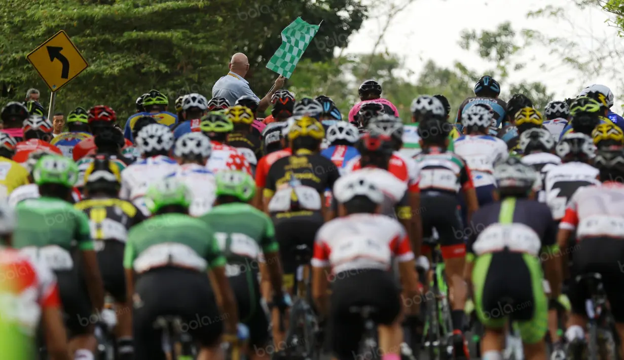 Race Director mengangkat bendera sebelum start pada etape 7 Tour de Singkarak 2016 di Kabupaten Sijunjung, Jumat (12/8/2016). (Bola.com/Nicklas Hanoatubun)