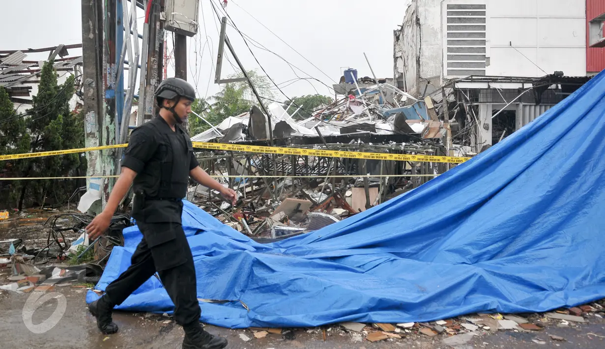 Petugas kepolisian melintas di depan outlet Pizza Hut Delivery (PHD) Jatimelati, Bekasi, yang hancur akibat sebuah ledakan, Minggu (23/10) pagi. Menurut pihak berwajib, tidak ada korban jiwa yang jatuh dalam ledakan tersebut. (Liputan6.com/Yoppy Renato)