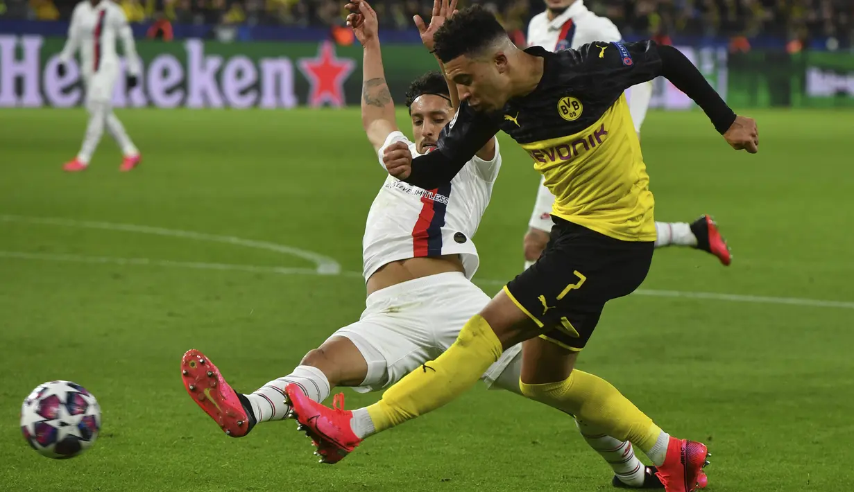 Gelandang Dortmund,  Jadon Sancho berusaha mengumpan bola dari kawalan bek PSG, Marquinhos pada pertandingan leg pertama babak 16 Liga Champions di Dortmund, Jerman (18/2/2020). Dortmund menang 2-0 atas PSG. (Bernd Thissen/dpa via AP)