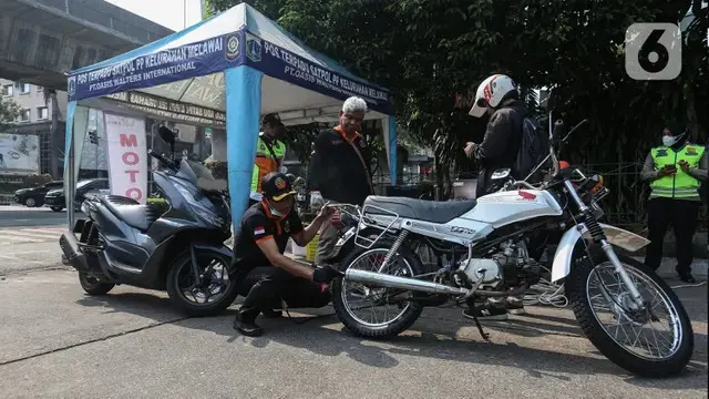 Petugas melakukan uji emisi kendaraan (Liputan6.com/Johan Tallo)