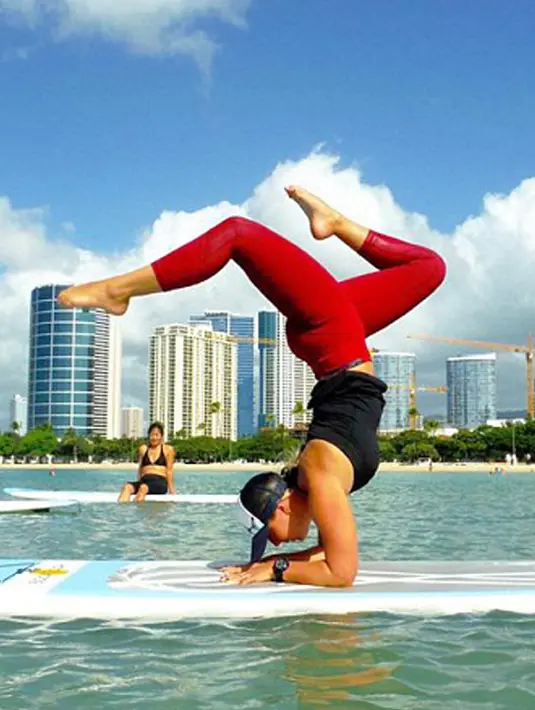 Pria melakukan aksi Yoga diatas papan selacar. Meskipun berbahaya mereka tetap melakukan kegiatan seperti ini. (Dailymail.co.uk)