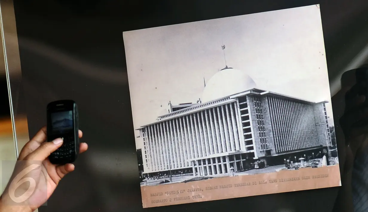 Warga memotret arsip foto Masjid Istiqlal yang dipamerkan di area Masjid Istiqlal di Jakarta, Jumat (24/2). Pameran ini untuk memeriahkan Milad Masjid Istiqlal dan berlangsung hingga 27 Februari. (Liputan6.com/Helmi Fithriansyah)