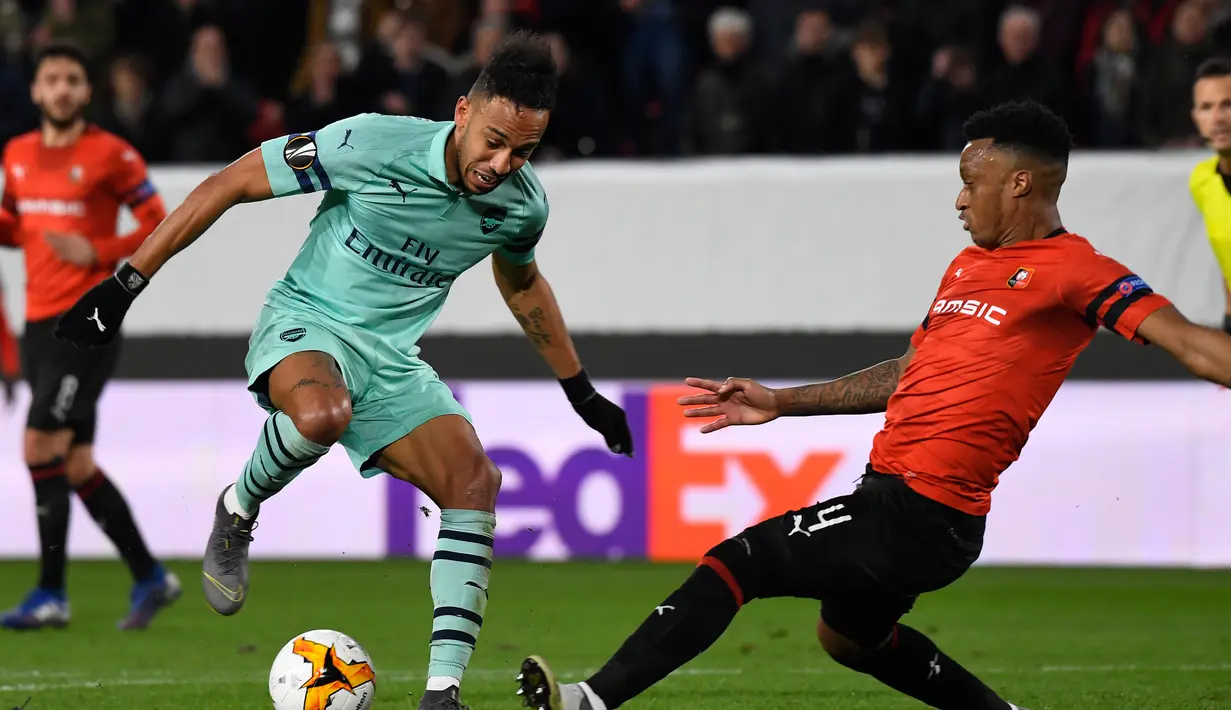 Aksi Aubameyang pada leg 1, babak 16 besar Liga Europa yang berlangsung di Stadion Roazhon Park, Rennes, Jumat (8/3). Arsenal kalah 1-3 kontra Rennes. (AFP/Damien Meyer)