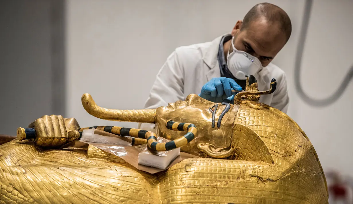 Mesir Segera Restorasi Peti Firaun: Arkeolog merestorasi peti mati emas Firaun Tutankhamun di laboratorium restorasi Grand Egyptian Museum (GEM), Giza, Mesir, Senin (13/4/2020). Firaun Tutankhamun merupakan Raja Mesir Kuno yang memerintah antara tahun 1342-1325 SM. (Khaled DESOUKI AFP)