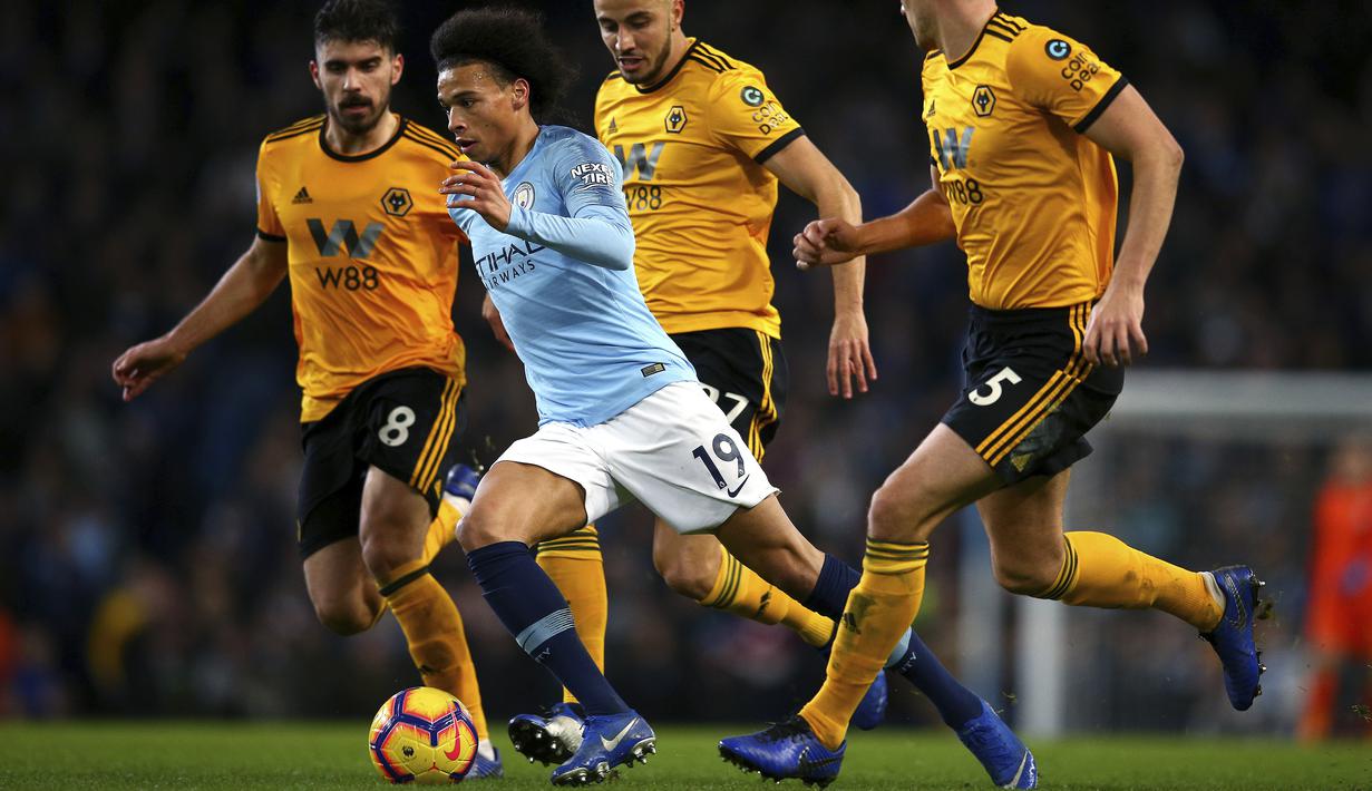 Gelandang Manchester City, Leroy Sane, berusaha melewati pemain Wolverhampton Wanderers pada laga Premier League di Stadion Etihad, Manchester, Senin (14/1). Manchester City menang 3-0 atas Wolverhampton Wanderers. (AP/Dave Thompson)