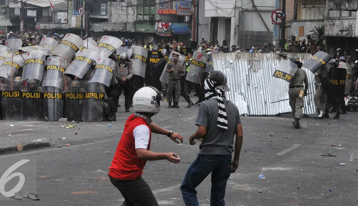 Warga Kampung Pulo menyerang Petugas saat penggusuran Kampung Pulo, Jakarta, Kamis (20/8/2015). Penggusuran pemukiman Kampung Pulo dilakukan oleh 2.200 personel gabungan untuk normalisasi Sungai Ciliwung. (Liputan6.com/Herman Zakharia)