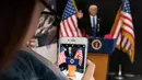Pelanggan mengabadikan boneka Donald Trump saat berpidato di toko mainan, Hong Kong (3/2). Pembuat boneka di Hong Kong yang sering menciptakan boneka pemimpin dunia yang kontroversial telah membuat patung Donald Trump. (AFP Photo/Anthony Wallace)