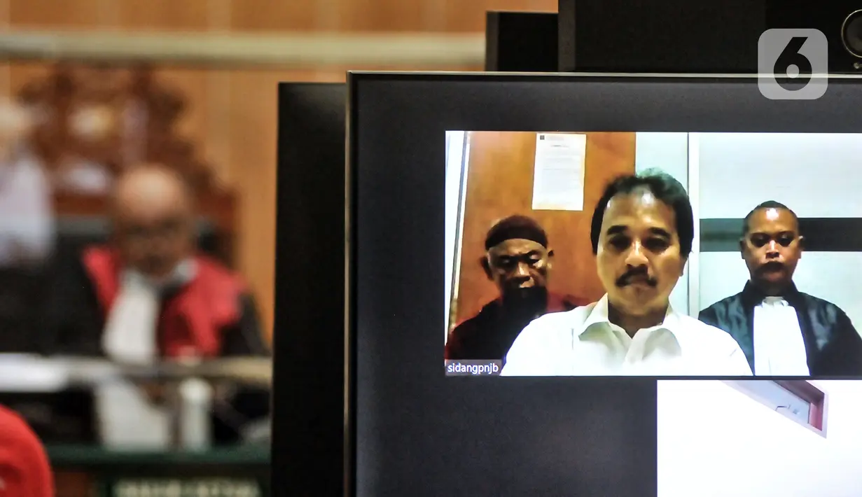 Layar menampilkan terdakwa Roy Suryo saat sidang perdana kasus meme stupa Candi Borobudur di Pengadilan Negeri Jakarta Barat, Rabu (12/10/2022). Sidang pembacaan dakwaan atas kasus meme stupa Candi Borobudur mirip Presiden Joko Widodo atau Jokowi tersebut dihadiri oleh terdakwa Roy Suryo secara virtual. (merdeka.com/Iqbal S. Nugroho)
