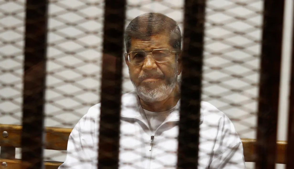 Mantan Presiden Mesir Mohammed Morsi duduk dalam penjara terdakwa di saat menjalani sidang di Akademi Kepolisian Nasional, Kairo, Mesir, 8 Mei 2019. Mohammed Morsi meninggal dalam sidang pengadilan pada Senin 17 Juni 2019 waktu setempat. (AP Photo/Tarek el-Gabbas, File)