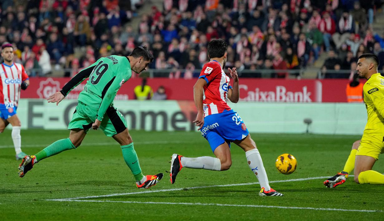 Striker Atletico Madrid, Alvaro Morata (kiri) mencetak gol kedua timnya ke gawang Girona pada laga pekan ke-19 Liga Spanyol 2023/2024 di Montilivi Stadium, Girona, Kamis (4/1/2024) dini hari WIB. (AFP/Pau Barrena)