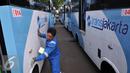 Petugas membersihkan Kopaja terintegrasi Transjakarta terparkir di Parkir Timur Senayan, Jakarta, Selasa (22/12). Saat ini terdapat 320 bus tampilan baru Kopaja AC yang akan beroperasi di rute-rute yang terintegrasi.  (Liputan6.com/Johan Tallo)