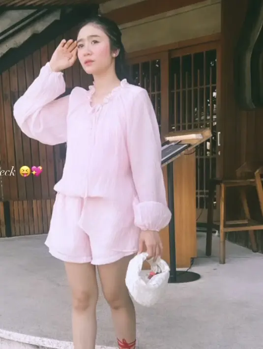 Febby juga tampil dengan atasan lengan panjang dan short pantas warna pink. Dengan membawa mini bag putih dan mengenakan sepatu model balet warna merah. [@febbyrastanty]