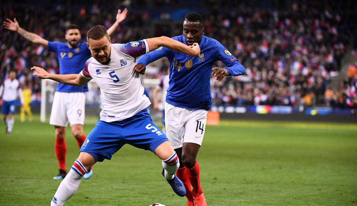 Bek Islandia, Sverrir Ingason hentikan pergerakan Matuidi pada laga kedua Kualifikasi Piala Eropa 2020 Grup H yang berlangsung di Stadion Stade de France, Paris, Selasa (26/3). Perancis menang 4-0 atas Islandia. (AFP/Franck Fife)