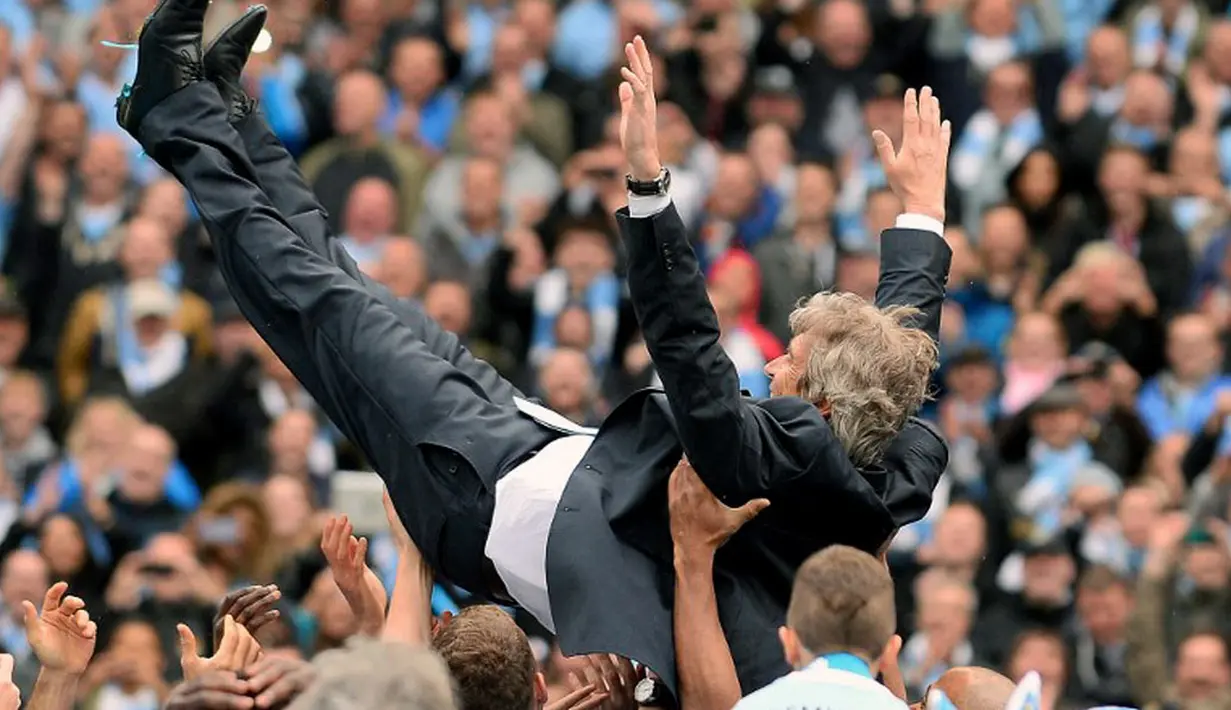 Pelatih Manchester City, Manuel Pellegrini, dilempar ke udara oleh pemainnya saat merayakan gelar juara Liga Primer di Stadion Etihad, Manchester (11/5/2014). (AFP PHOTO/Andrew Yates) 
