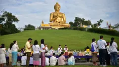 Umat Buddha berkumpul di samping patung Buddha raksasa saat mereka memperingati Hari Makha Bucha di kota Narathiwat, Thailand selatan (6/3/2023). Makha Bucha merupakan salah satu hari raya terpenting bagi para penganut agama Buddha. (AFP/Madaree Tohlala)