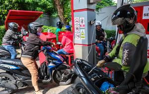 Pertamina Patra Niaga akan mengedepankan keandalan layanan serta kesinambungan distribusi energi nasional. Tampak dalam foto, para pengendara sepeda motor mengantre untuk mengisi bahan bakar sepeda motor mereka di sebuah Stasiun Pengisian Bahan Bakar Umum (SPBU), Jakarta pada Rabu 1 April 2026. (BAY ISMOYO/AFP)