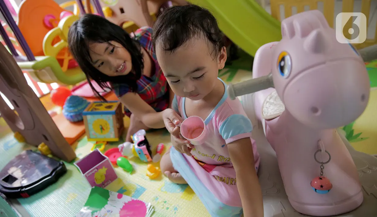 Dua orang anak bermain di dalam rumah di Kawasan Jakarta, Minggu (29/3/2020). Aktivitas bermain di dalam rumah saat ini menjadi alternatif warga dalam mengurangi interaksi sosial sebagai upaya pencegahan penyebaran virus corona atau COVID-19. (Liputan6.com/Faizal Fanani)