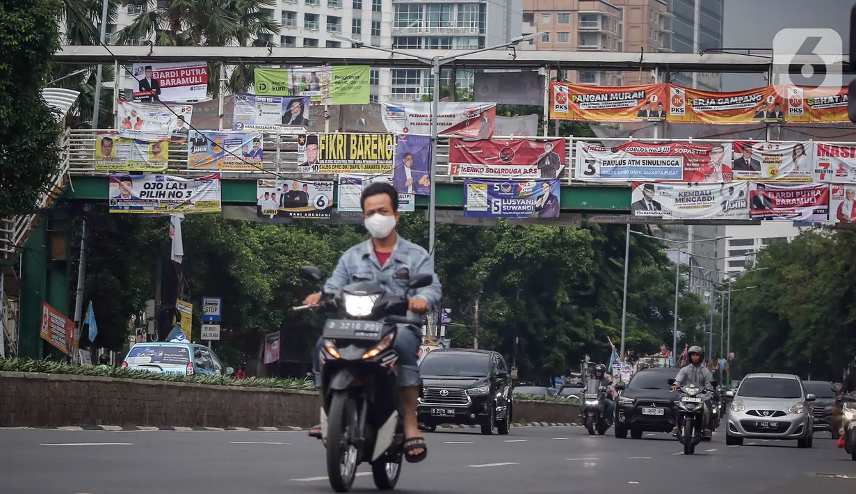 Kendaraan melintas di bawah Jembatan Penyeberangan Orang (JPO) yang tertutup oleh alat peraga kampanye (APK) Pemilu 2024 di Jakarta, Rabu (27/12/2023). (Liputan6.com/Angga Yuniar)
