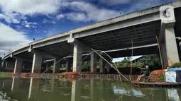 Warga menangkap ikan dengan jaring apung di bawah jalan Tol Serpong-Cinere, Setu Sasak Tinggi, Pamulang, Tangerang Selatan, Banten (6/4/2021). Setu Sasak Tinggi dimanfaatkan warga menangkap ikan mujair. (merdeka.com/Arie Basuki)