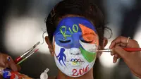 Siswa dari India mengecat wajahnya dengan logo Olimpiade Rio 2016 untuk mendukung tim India di Chennai, India, (4/8/2016). (AFP/Arun Sankar)