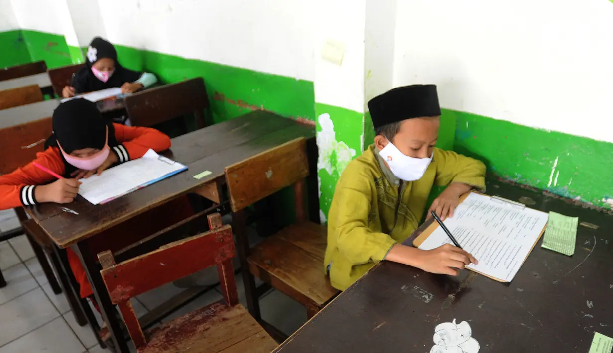 Murid kelas V mengikuti ujian Penilaian Akhir Semester (PAS) tahun pelajaran 2020/2021 di Madrasah Ibtidayah (MI) Assu'ada di Pancoran Mas, Depok, Jawa Barat, Selasa (1/12/2020). Ujian dilaksanakan dengan menerapkan protokol kesehatan dalam kelas. (merdeka.com/Arie Basuki)
