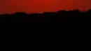 Orang-orang menyaksikan matahari terbenam sambil berperahu di Shawnee Mission Lake, Shawnee, Kansas, Amerika Serikat, Jumat (9/10/2020). Matahari terbenam terus lebih cerah dari biasanya karena asap dari kebakaran hutan barat terus melayang di seluruh negeri. (AP Photo/Charlie Riedel)