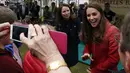 Salah satu warga Forteviot, Skotlandia terlihat mengabadikan kedatangan Duchess of Cambridge, Catherine Elizabeth Middleton dengan kamera ponsel, (29/5/2014). (REUTERS/Russell Cheyne)