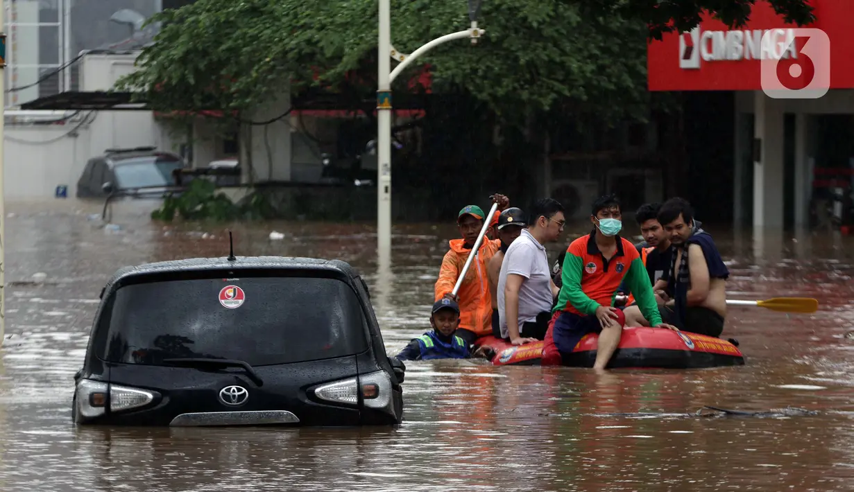 Petugas menggunakan perahu karet mengevakuasi beberapa warga yang terjebak banjir di kawasan Jalan Kemang Raya, Jakarta, Sabtu (20/2/2021). Hujan yang mengguyur Jakarta sejak Jumat (19/2) membuat sejumlah titik di Jakarta terendam banjir. (Liputan6.com/Helmi Fithriansyah)