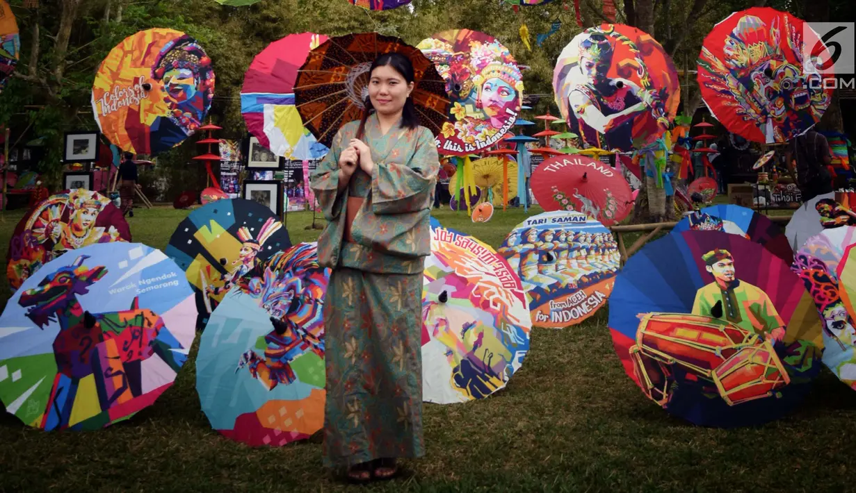 Pengunjung berfoto di sekitar dekorasi payung pada acara Festival Payung Indonesia 2018 di Taman Lumbini, Komplek Candi Borobudur, Magelang, Jumat (7/9). Acara tahunan kali ini bertema 'Sepayung Indonesia, Lalitavistara'. (Liputan6.com/Gholib)