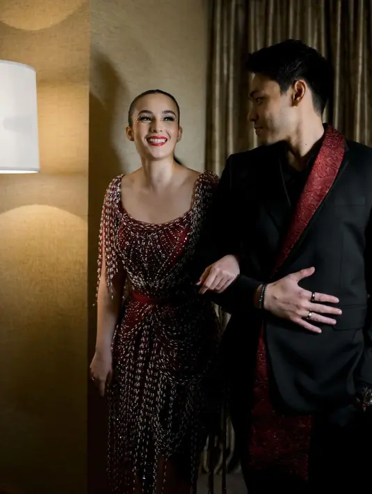 Sang suami Rob Cardinal juga menambahkan aksen merah pada setelan jasnya yang membuat tampilan sehati. [@hiantjen]