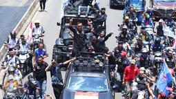 Pasangan Agus H Yudhoyono dan Sylviana Murni menyapa warga saat berada di mobil karnaval di Thamrin, Jakarta, Sabtu (29/10). Karnaval tersebut merupakan bentuk kampanye damai untuk pemilihan Gubernur DKI Jakarta. (Liputan6.com/Angga Yuniar)