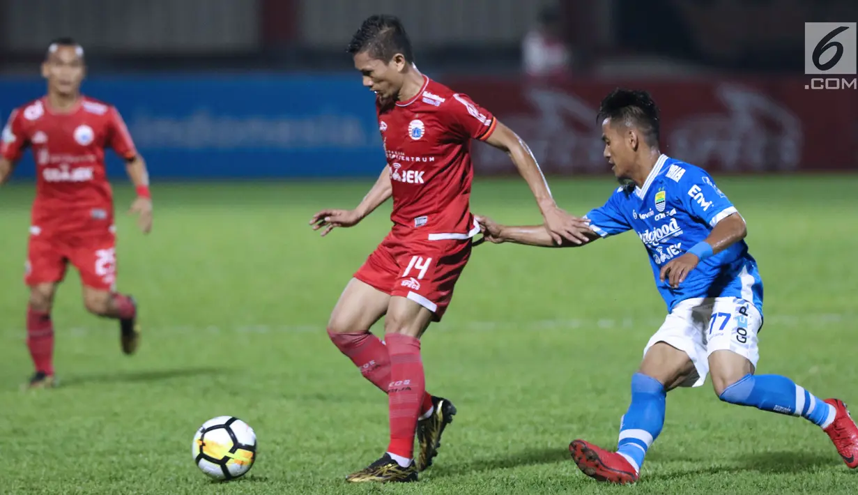 Bek Persija, Ismed Sofyan (tengah) mengecoh pemain Persib, Ghozali Muharam pada lanjutan Go-Jek Liga 1 Indonesia 2018 bersama Bukalapak di Lapangan PTIK, Jakarta, Sabtu (30/6). Persija unggul 1-0. (Liputan6.com/Helmi Fithriansyah)
