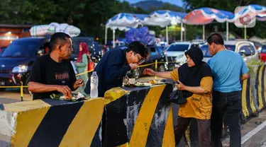 Pemudik beristirahat sambil menyantap makanan di dermaga penyebrangan di Pelabuhan Merak, Cilegon, Banten, Sabtu (6/4/2024). (Liputan6.com/Angga Yuniar)