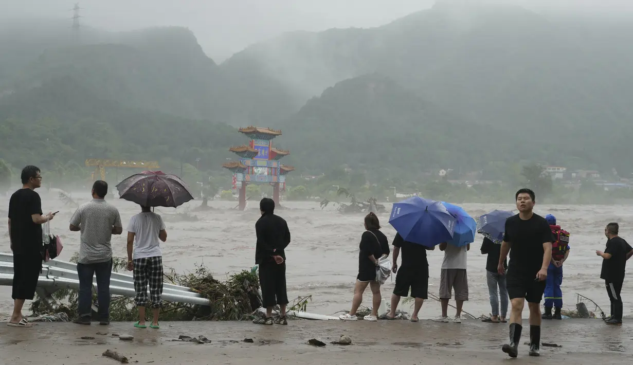 Rumah-rumah terendam banjir, jalan-jalan hancur dan mobil-mobil bertumpuk. (AP Photo/Ng Han Guan)