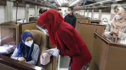 Petugas melayani penumpang kereta api di Stasiun Gambir, Jakarta, Jumat (22/4/2022). Stasiun Gambir per Jumat (22/4/2022) terdapat 33 KA beroperasi, dari jumlah tersebut 7 diantaranya merupakan KA tambahan. (Liputan6.com/Herman Zakharia)