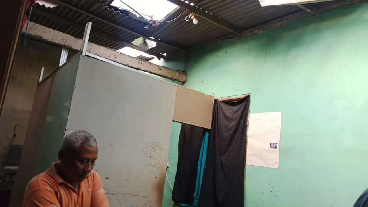 Rumah salah satu warga rusak tertimpa puing papan reklame saat hujan deras mengguyur wilayah Tangerang Selatan