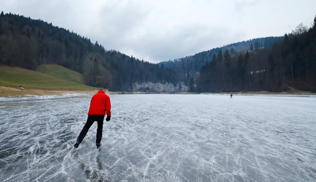 Seorang wisatawan asyik bermain ice skating atau seluncur es di atas sungai Doubs yang membeku di perbatasan Perancis Les Brenets, Swiss, Senin (2/1). Sungai ini menjadi objek wisata es yang diminati warga. (REUTERS/Denis Balibouse)