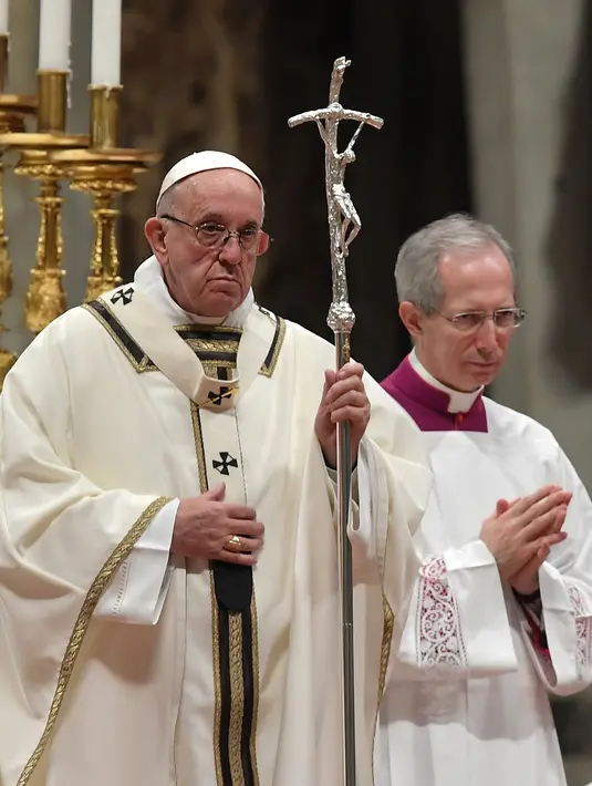 Paus Fransiskus saat memimpin misa Natal di Basilika Santo Petrus, Vatikan, (24/12). Dalam misa tersebut, Paus mengungkapkan kelahiran Yesus di sebuah kandang seharusnya membuat masyarakat mampu merenungkan makna hidup. (AFP Photo/Tiziana Fabi)